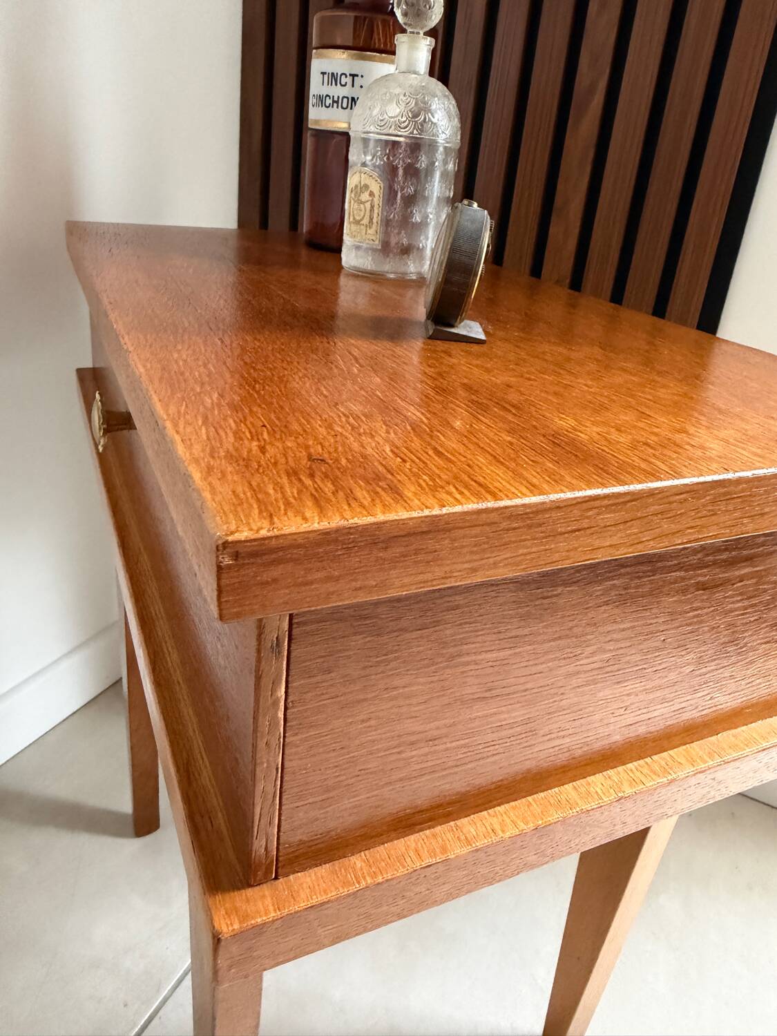 Vintage bedside table with tapered legs.