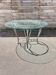 Round table, glass top, wrought iron base.