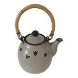 Beige stoneware teapot with stylized flowers and rattan handle
