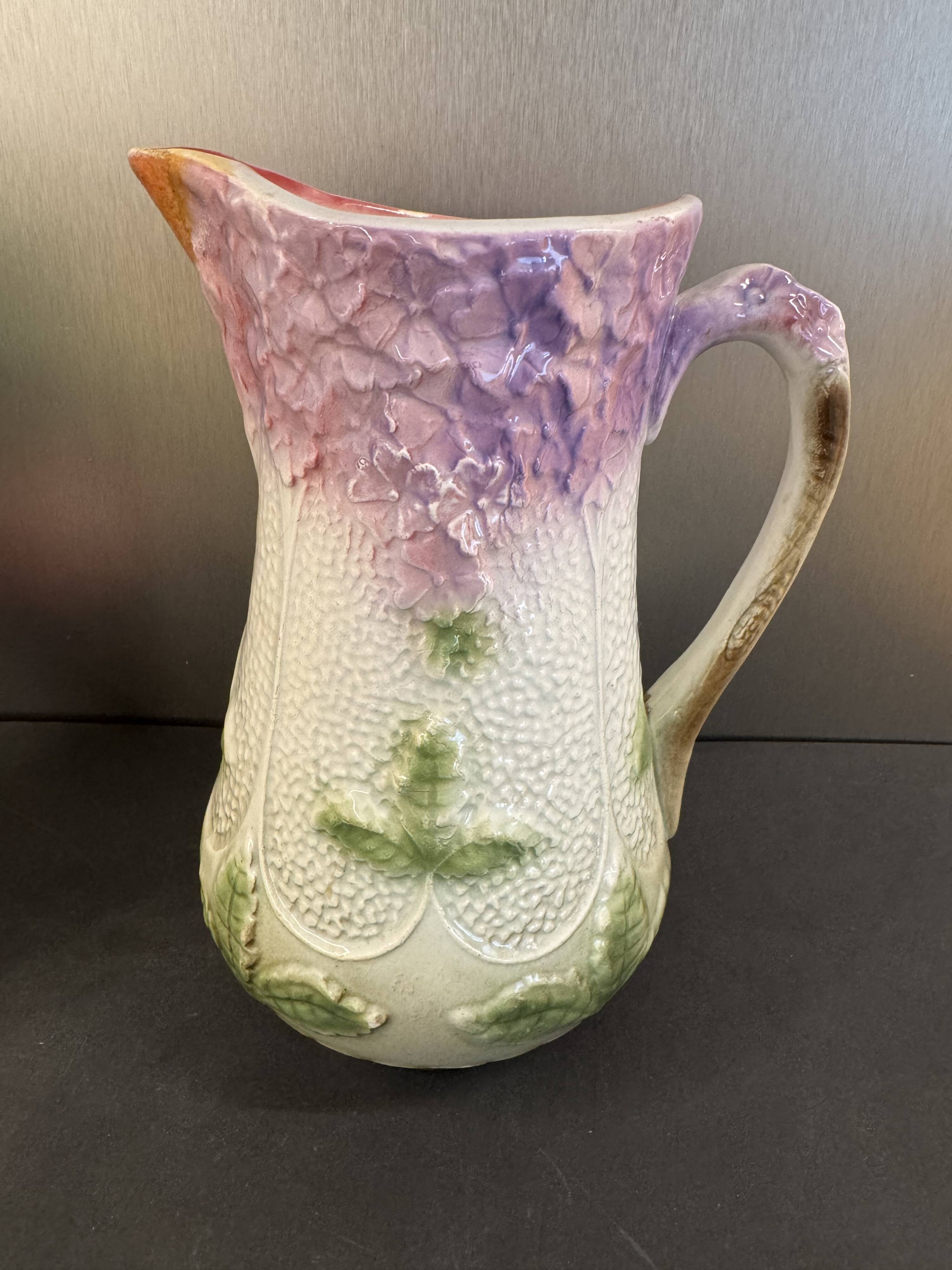 Ancien pichet en barbotine à décor floral mauve