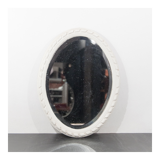 Miroir des années 1950 constitué d'un cadre en bois peint et d'une glace ovale.