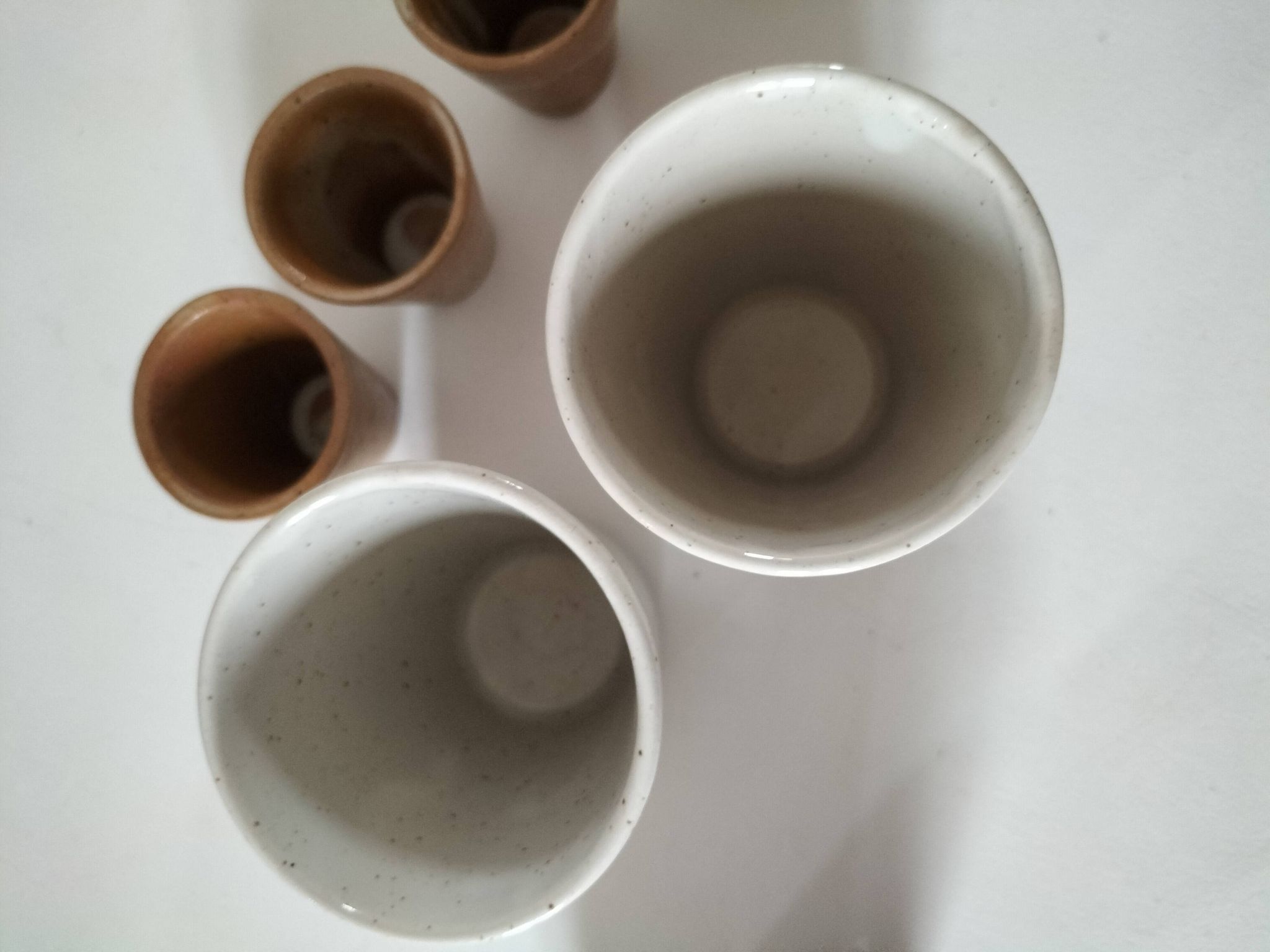 Set of 8 stoneware cups and a mug, shades of beige.