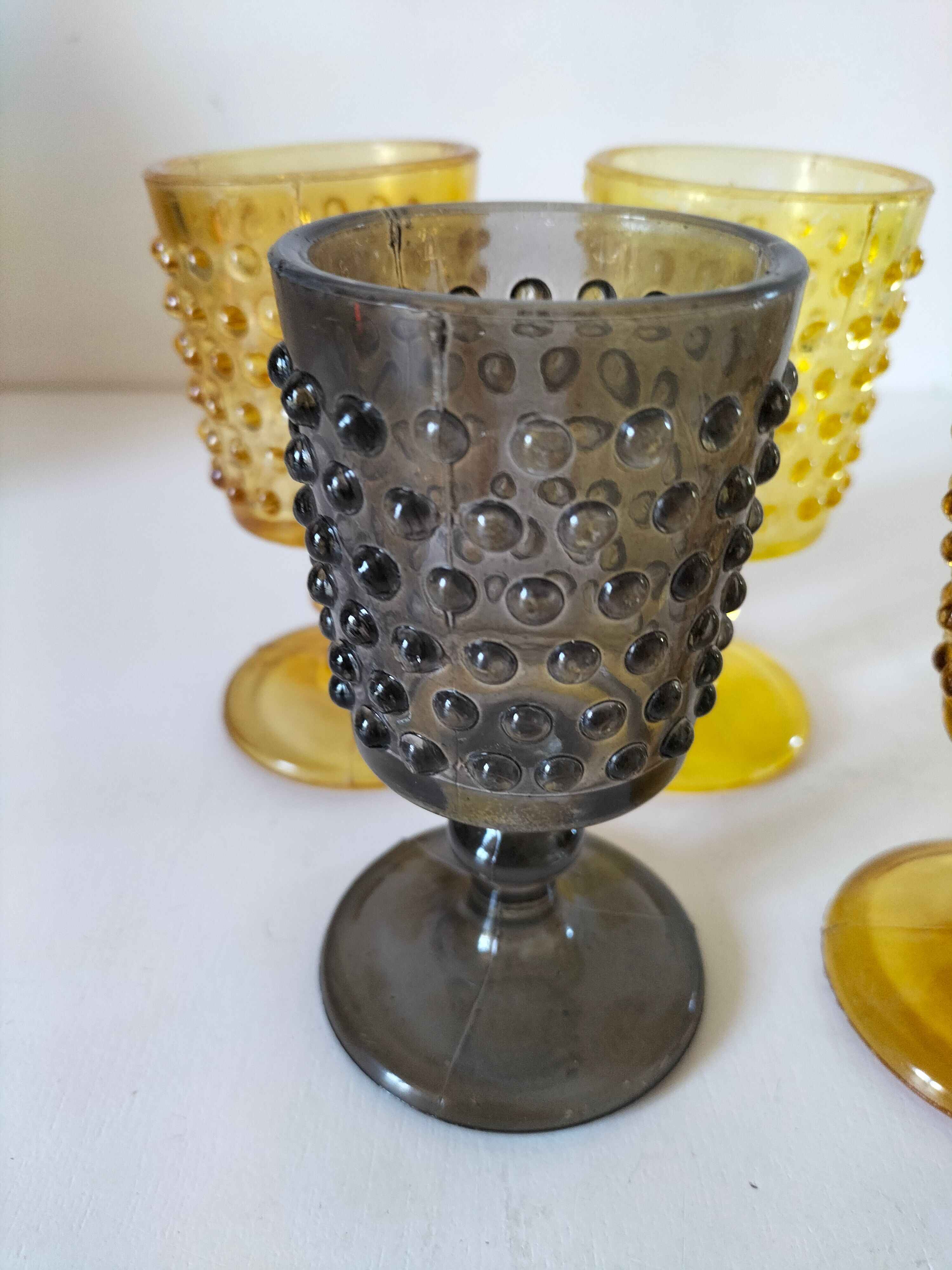 4 vintage stemmed glasses in hobnail glass and smoke colour.