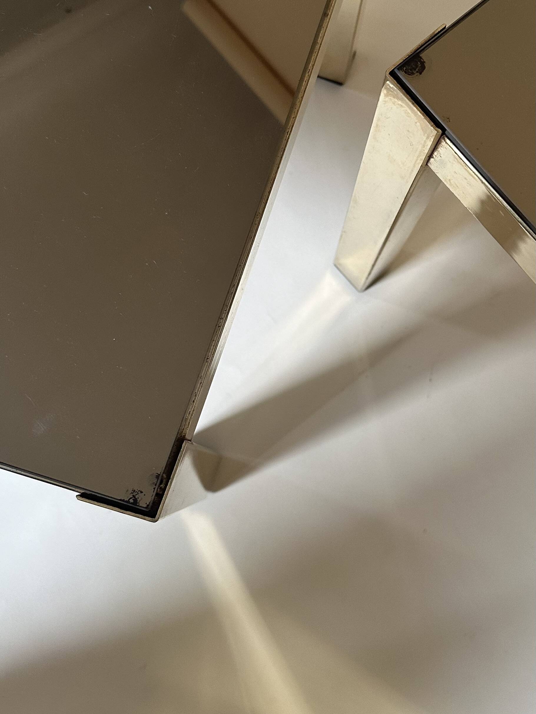 Set of three nesting side tables in brass and smoked mirror.