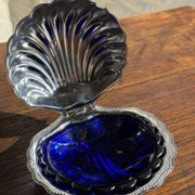 Vintage silver-plated shell butter dish with blue bowl.
