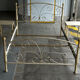 Patinated metal and wood double bed with integrated bedside tables.