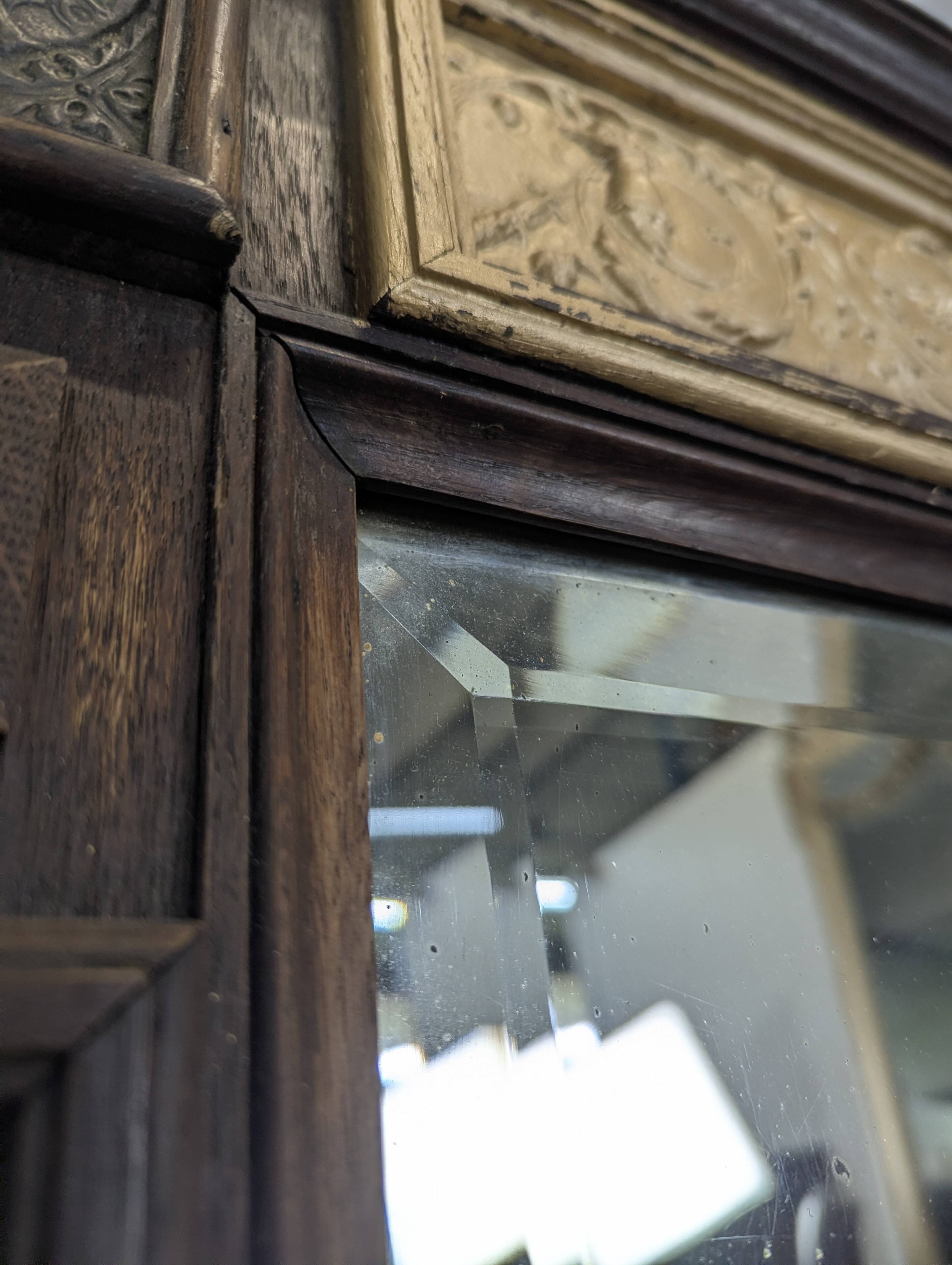 Renaissance-style mirror in wood and copper with a craftsmanship theme.