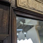 Renaissance-style mirror in wood and copper with a craftsmanship theme.