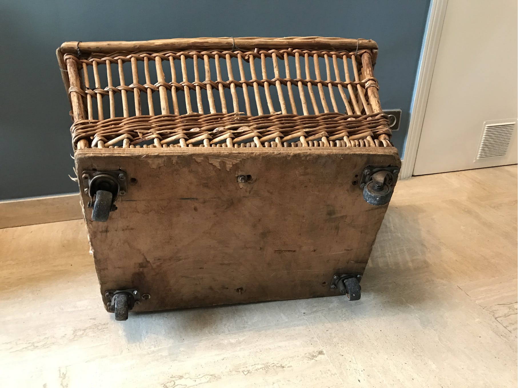 Rattan laundry basket on vintage wheels