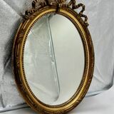 Antique oval gilded mirror with wooden frame and stucco detail