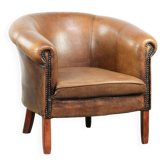 Sheepskin club armchair in a brown colour finished with decorative nails