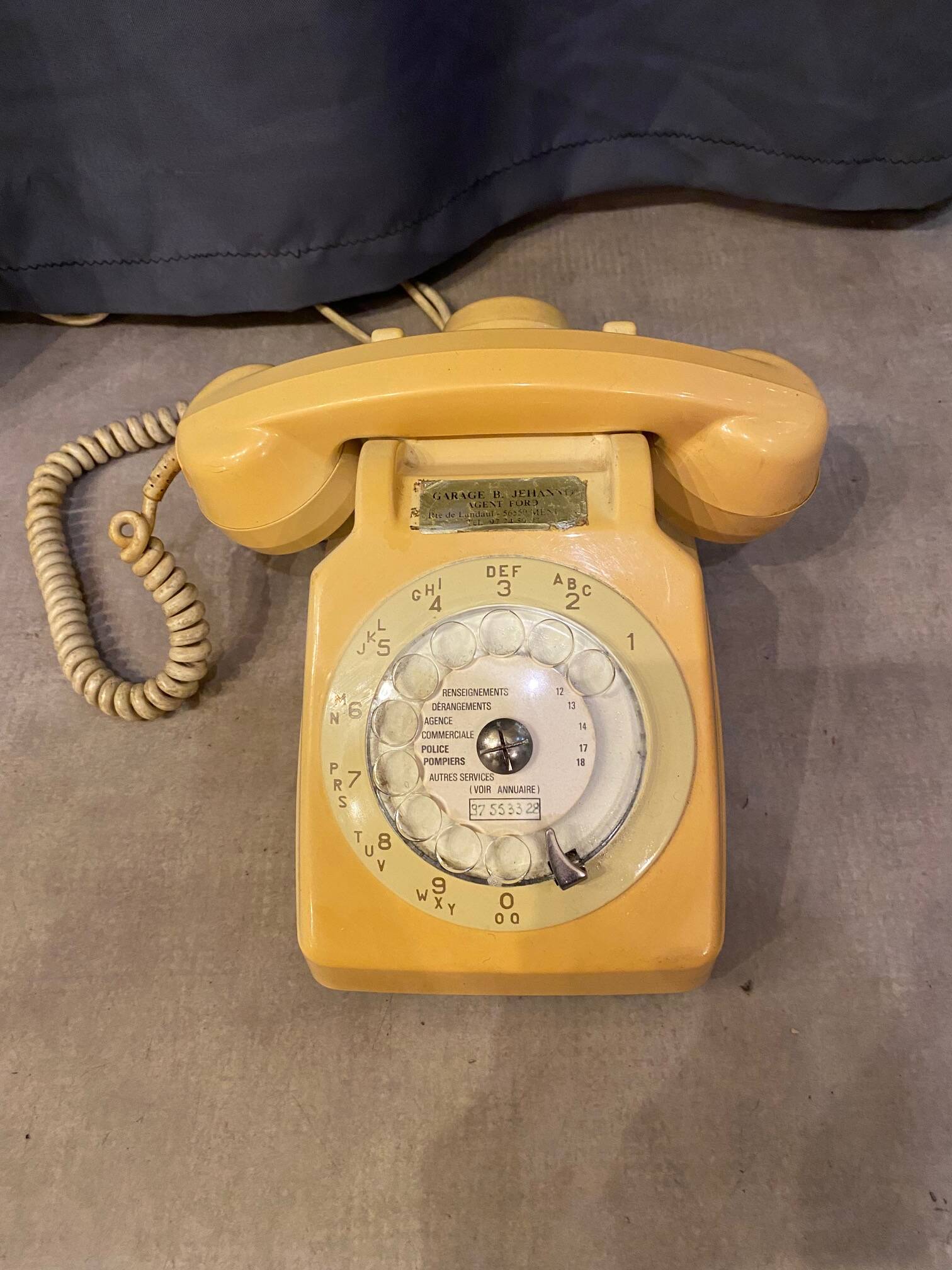Old dial telephone from the 80s temat quimper bakelite yellow and beige