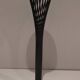 Brass ashtray on a stand made of black lacquered metal wire.