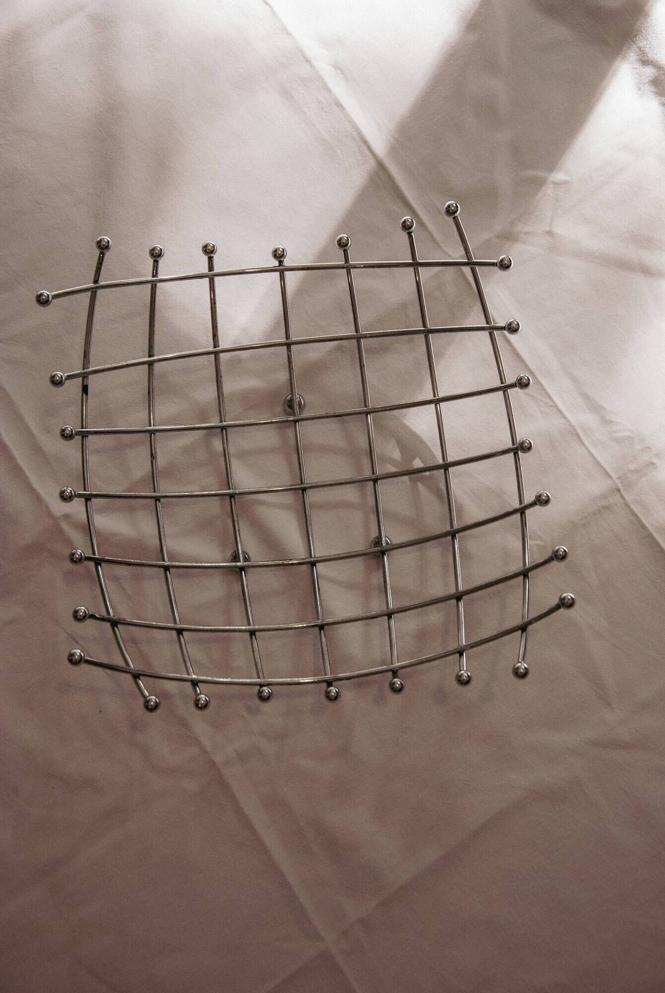Curved grid fruit bowl, chrome metal and beads.