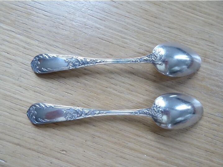 2 small white metal spoons