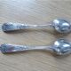 2 small white metal spoons