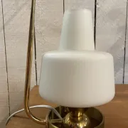 Table lamp in gold metal and opaline.