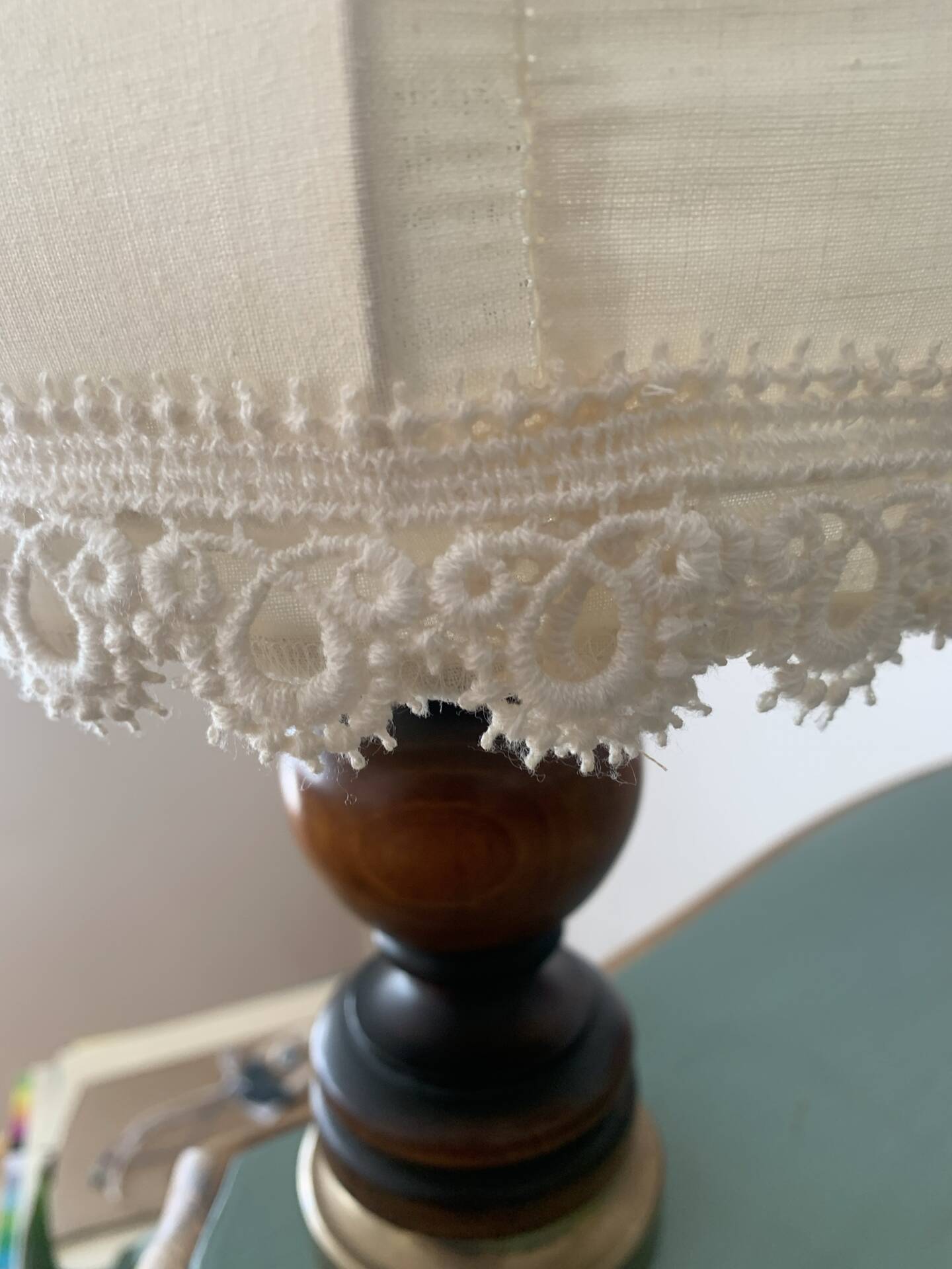 Small vintage wooden turned table lamp with a pleated shade.