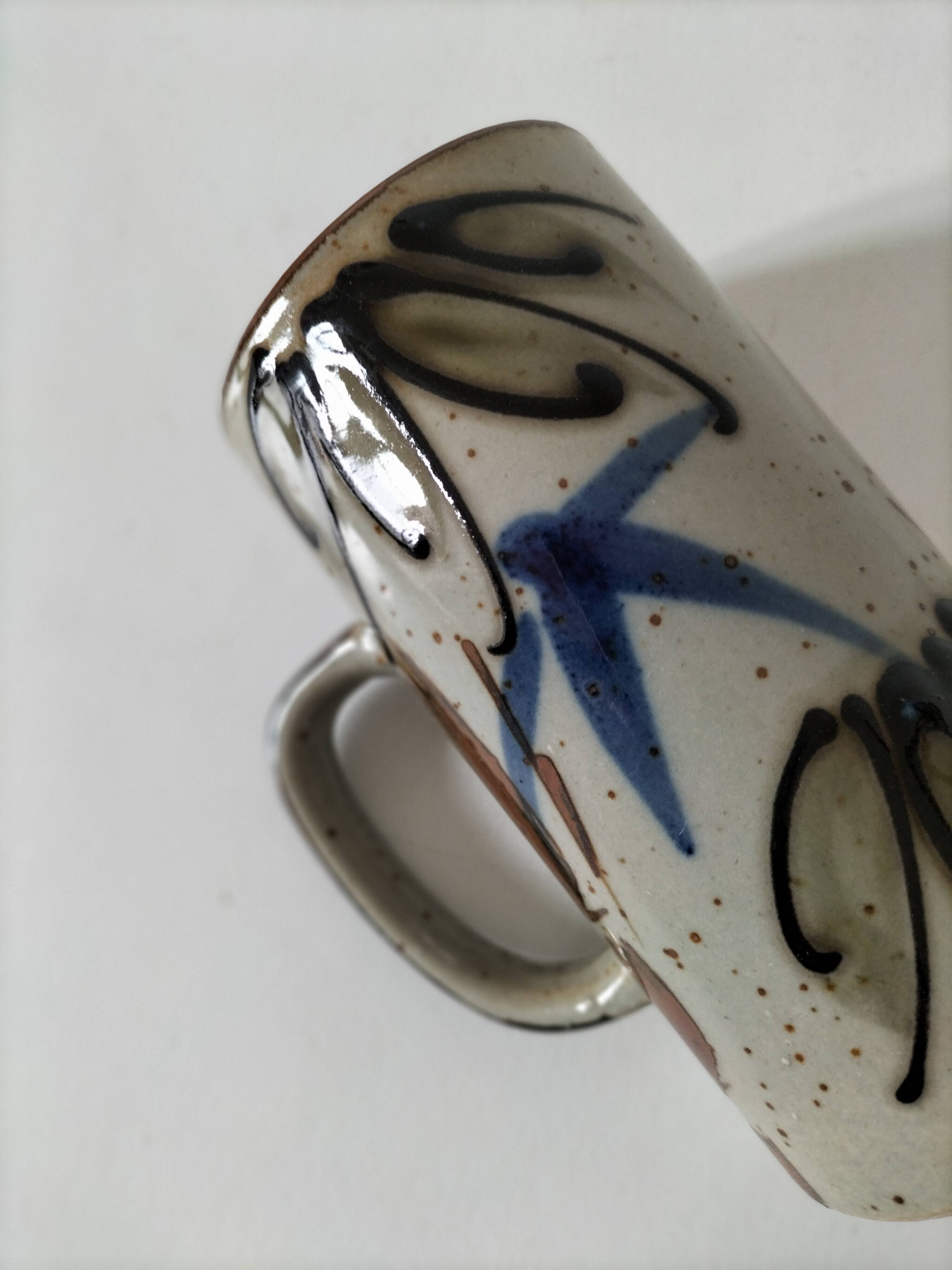 Glazed stoneware mug with free decoration, vintage pottery work.
