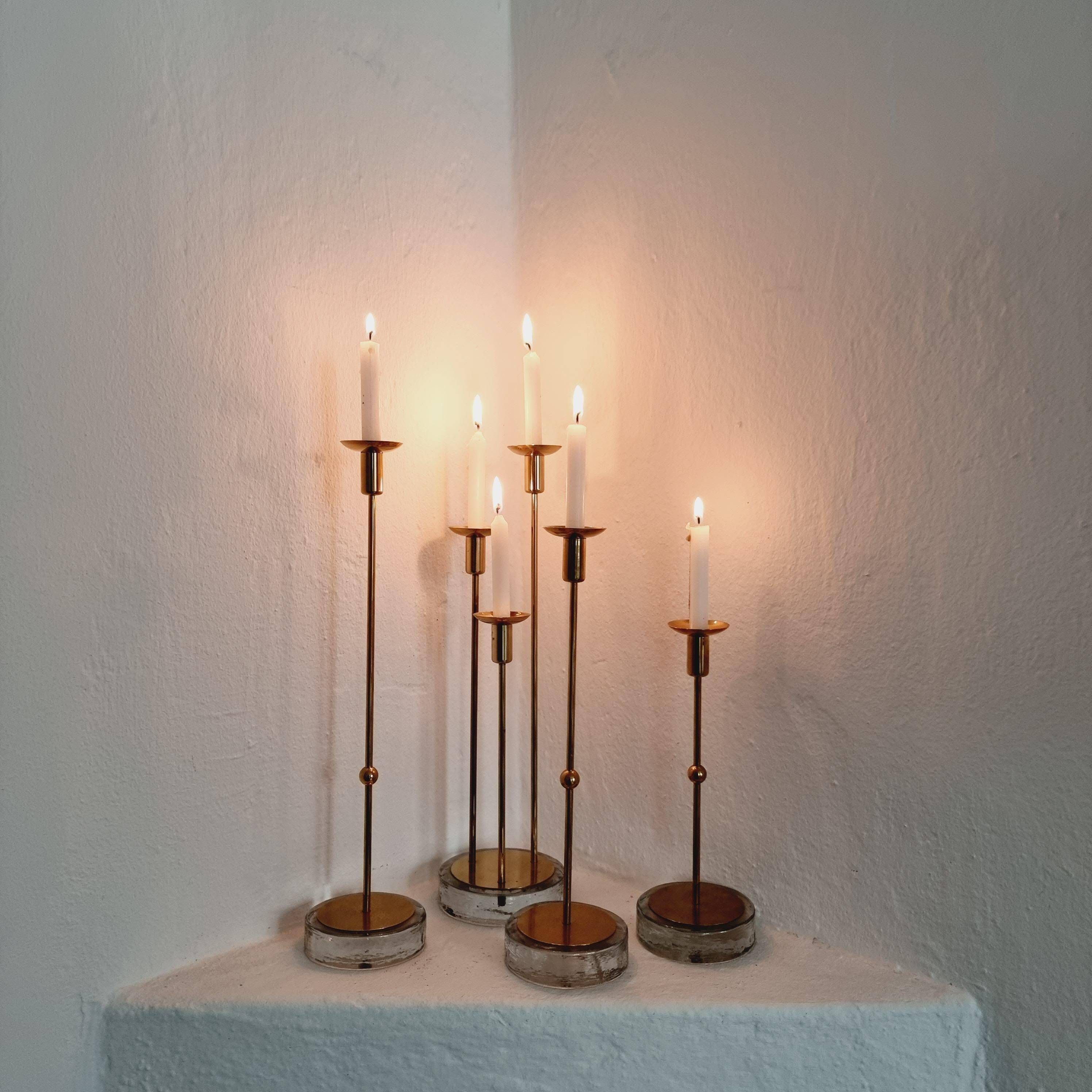 Gunnar Ander, four candlesticks, brass and glass, Ystad Metall, Swedish modern.