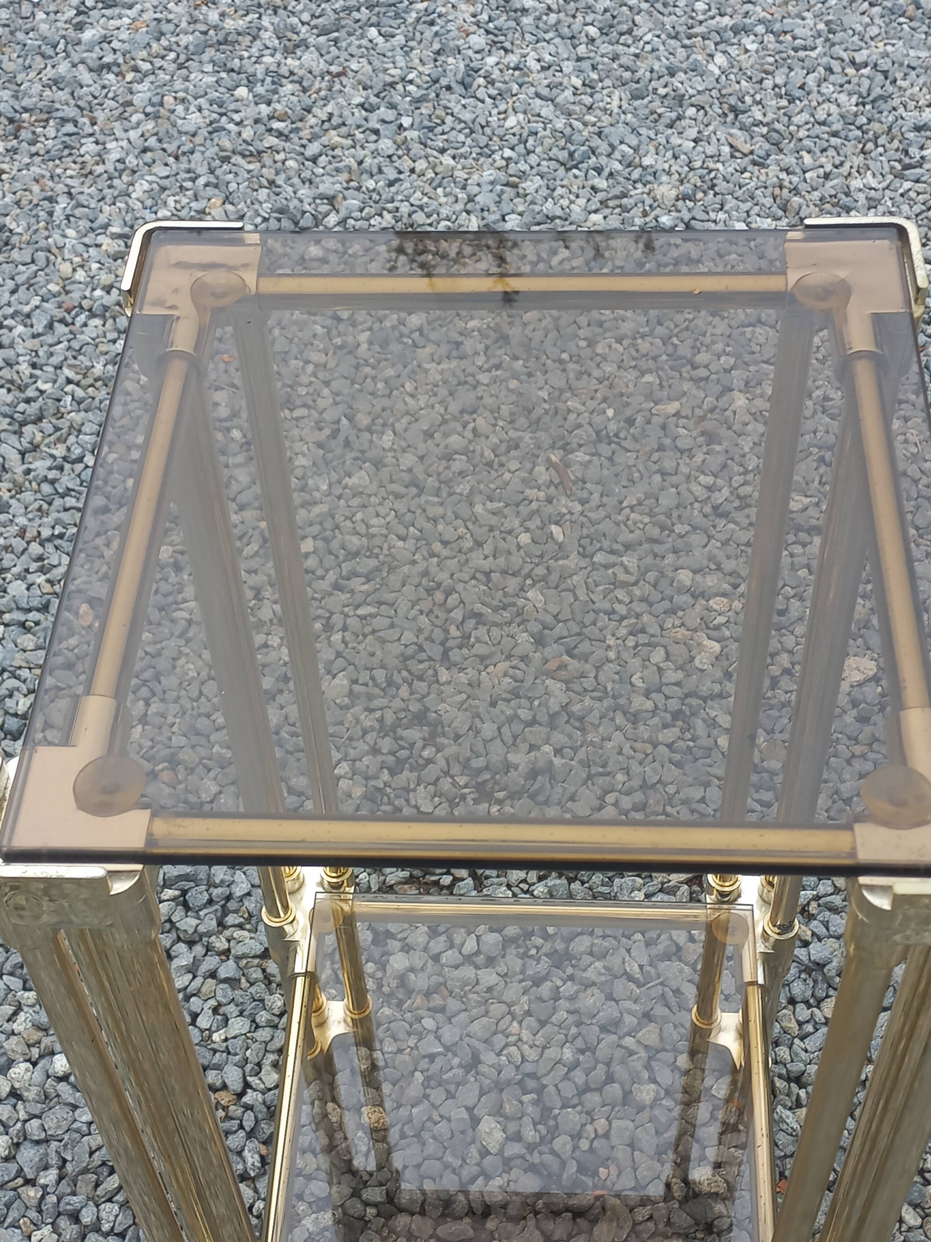 Pair of Hollywood Regency side tables in gold metal and smoked glass.