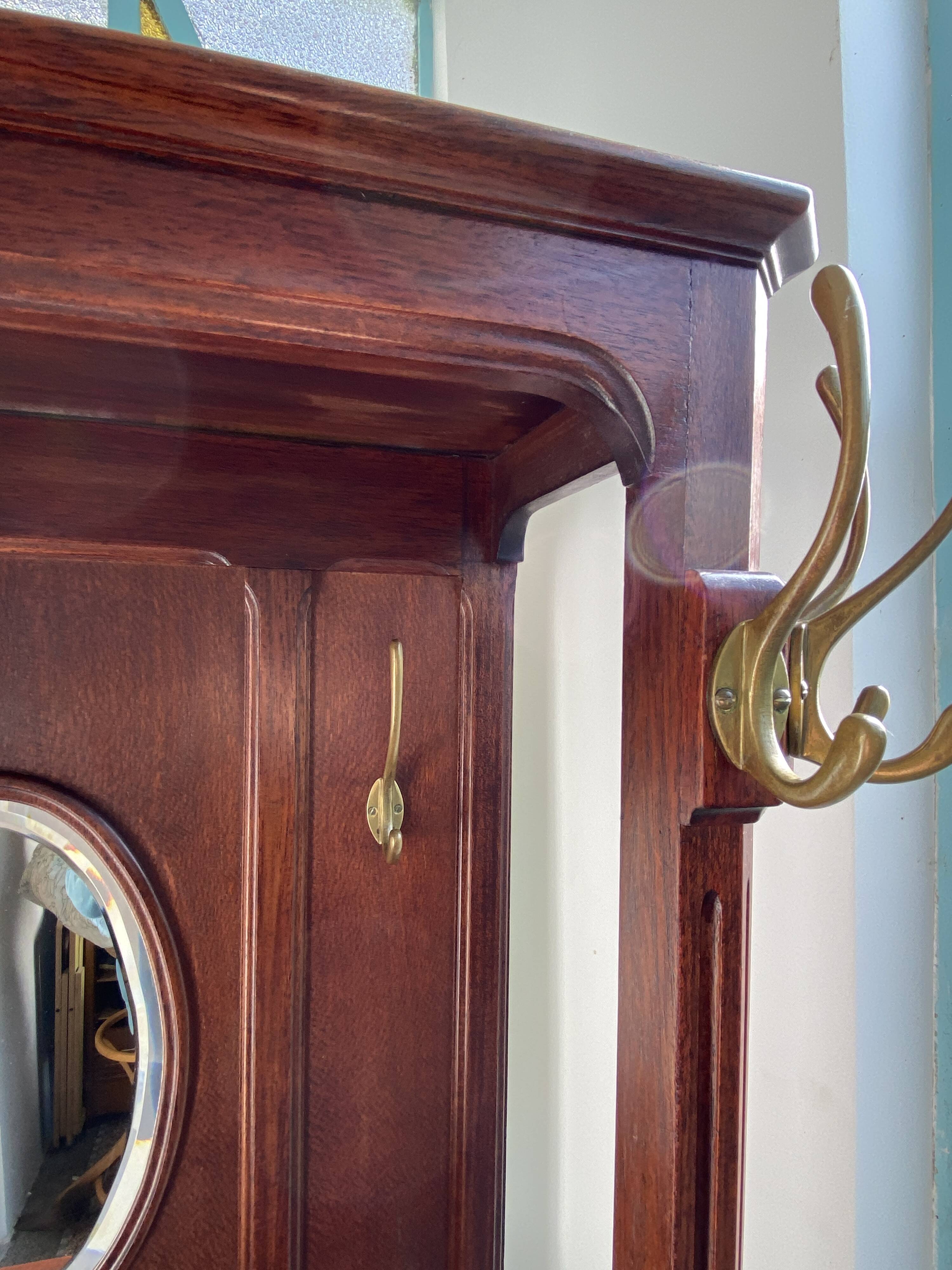 Antique wooden coat rack with mirror and shelf.