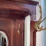 Antique wooden coat rack with mirror and shelf.