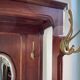 Antique wooden coat rack with mirror and shelf.