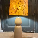 Large beige ceramic table lamp with a vintage shade.