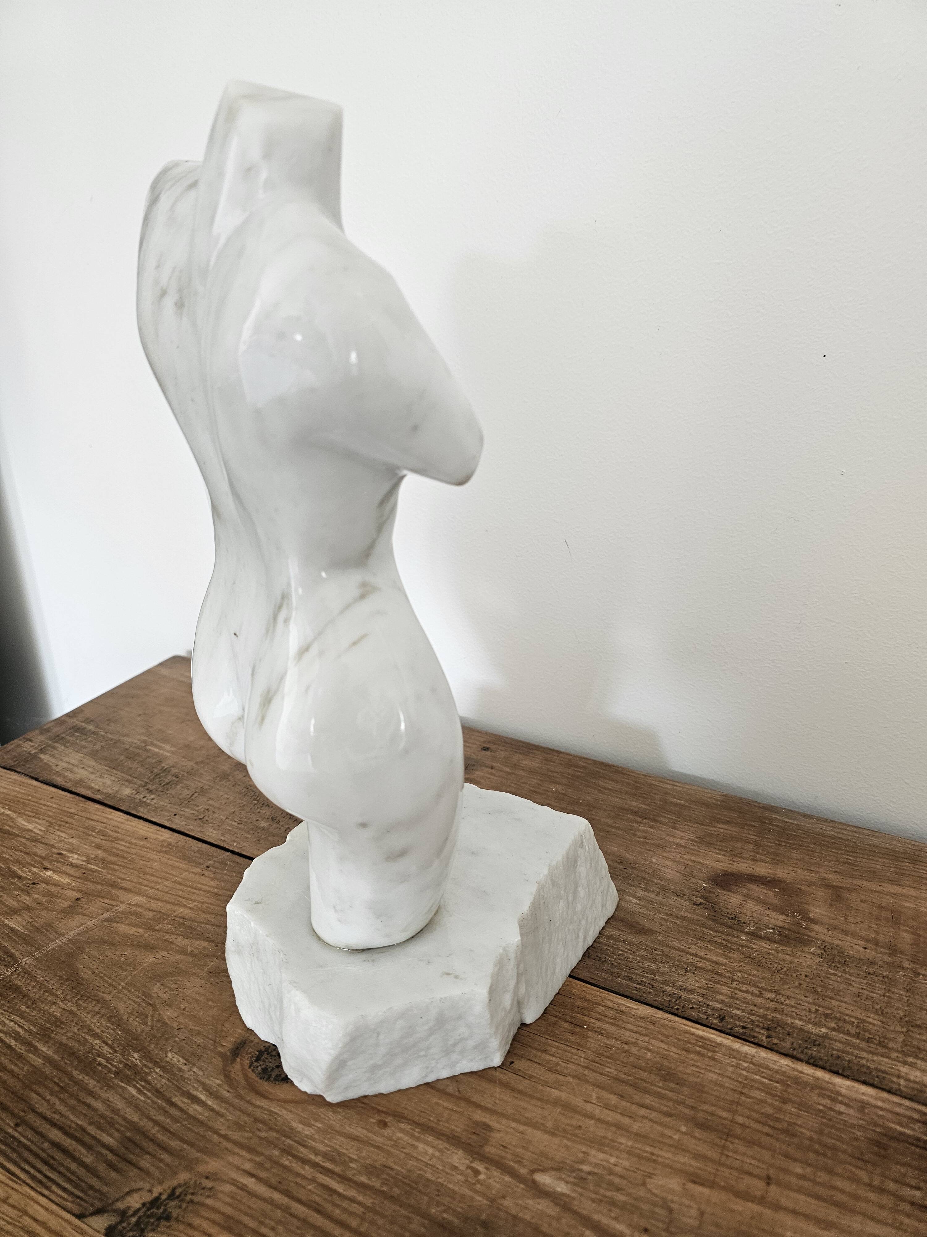 Sculpture of a female torso in white marble.
