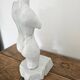 Sculpture of a female torso in white marble.
