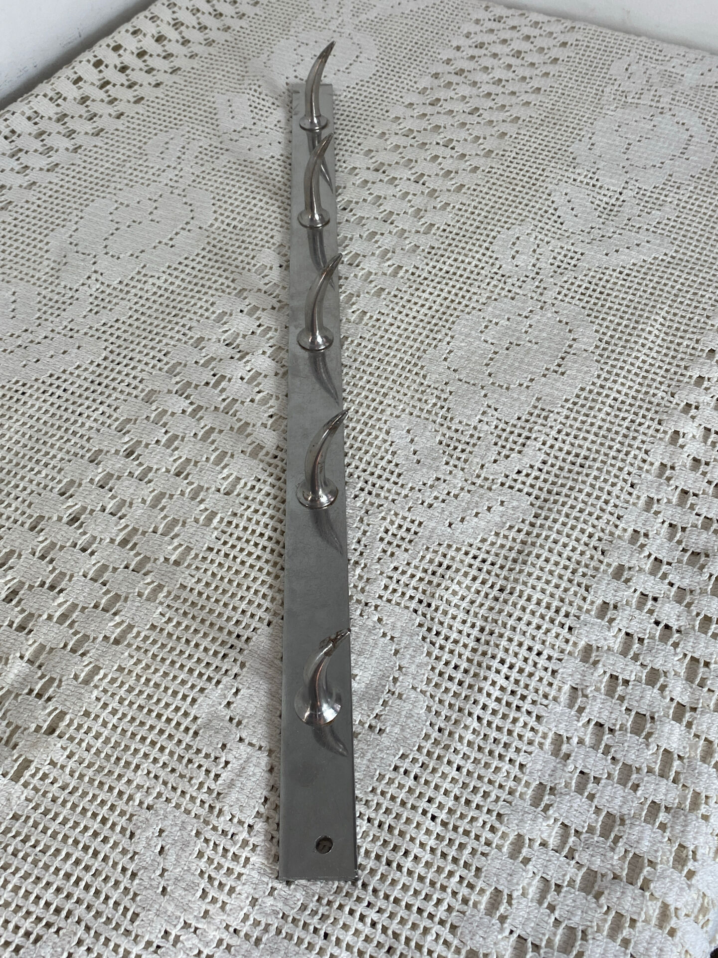 Stainless steel butcher's hook, known as a "wolf tooth bar."