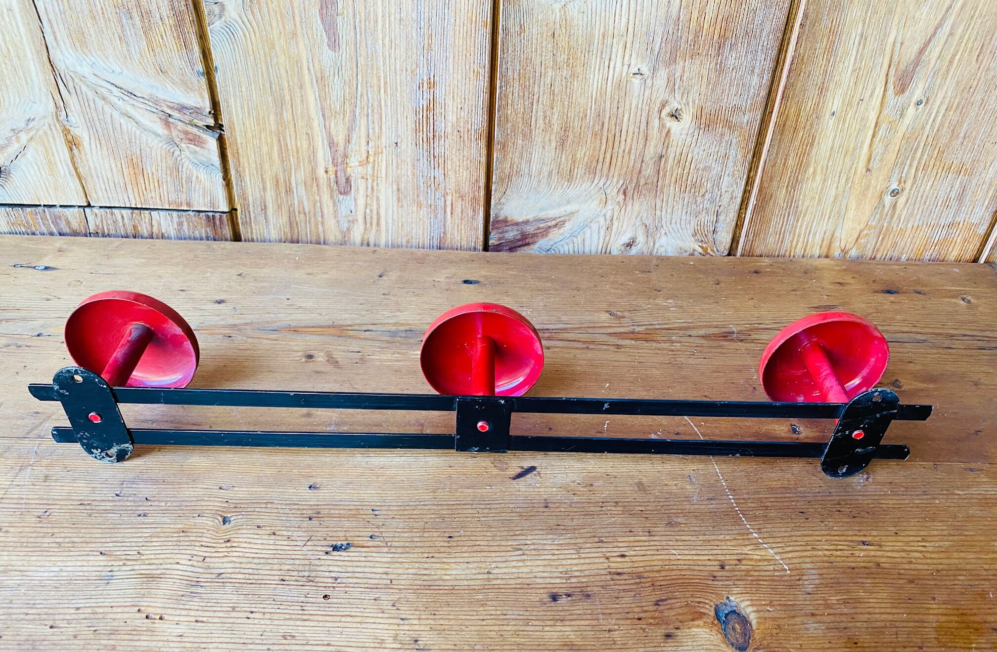 Wall coat rack in vintage red metal.