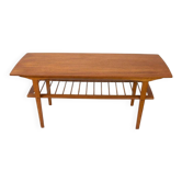 Scandinavian coffee table in teak with a lower shelf and brass bars.