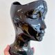 Black ceramic vase with a woman's face.