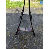Vintage table with a glass top and smoked plastic trestle legs.