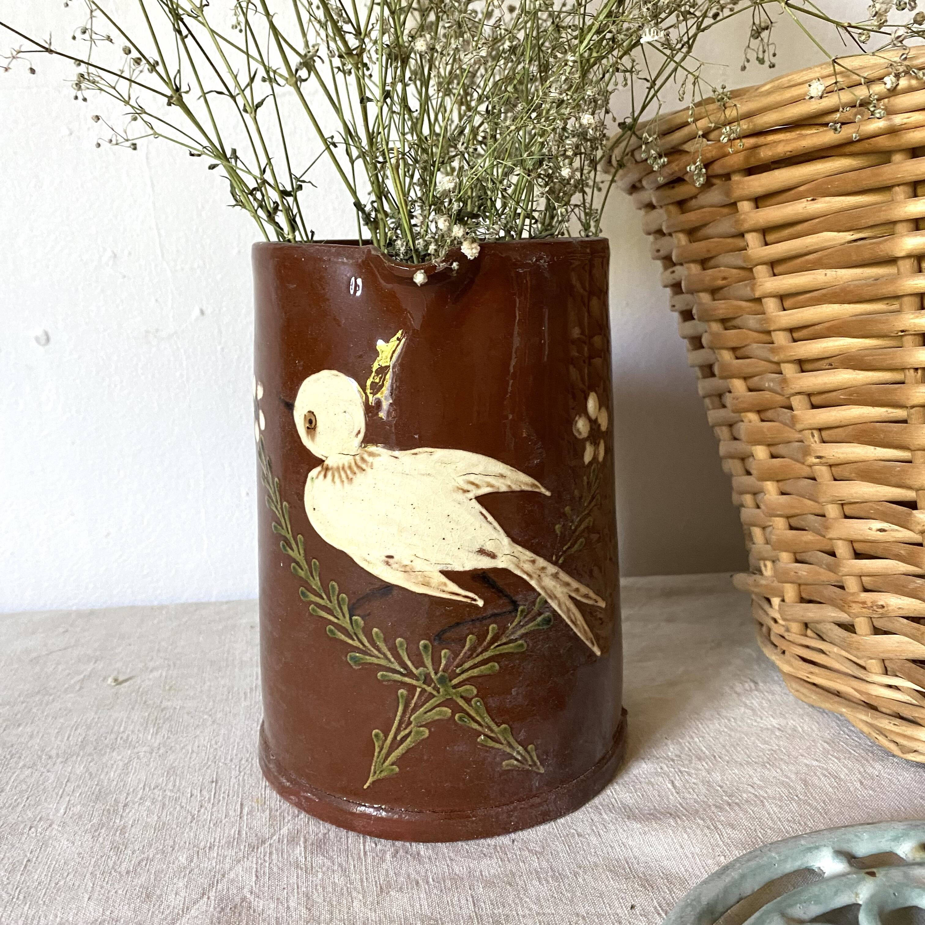 Terracotta pitcher with hand-painted bird decor