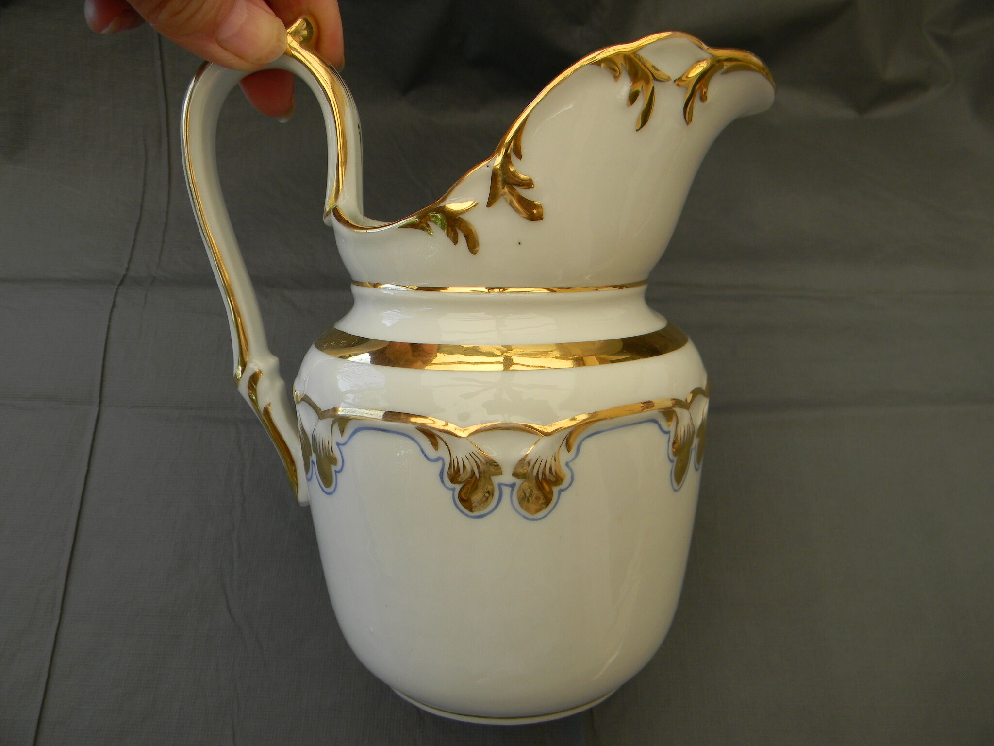 Milk jug or antique pitcher in white and gold porcelain.