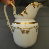 Milk jug or antique pitcher in white and gold porcelain.