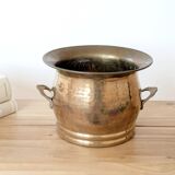 Vintage round cache-pot in hammered brass with decorative handles and patina.