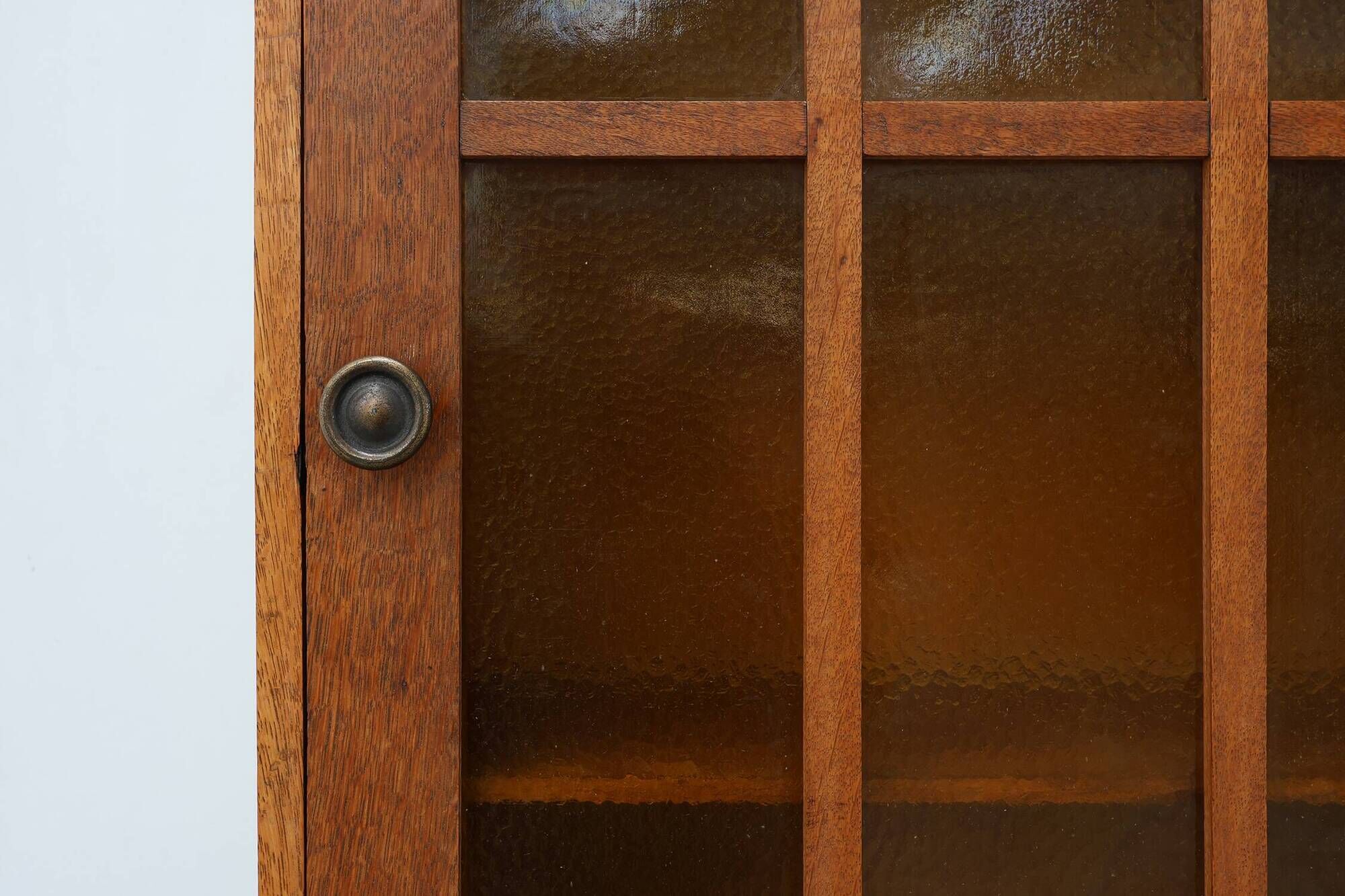 Art Deco oak wall cabinet with amber glazed door, Belgium ca. 1925