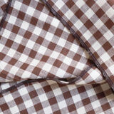 Nappe volantée en lin blanche et serviettes vichy marron