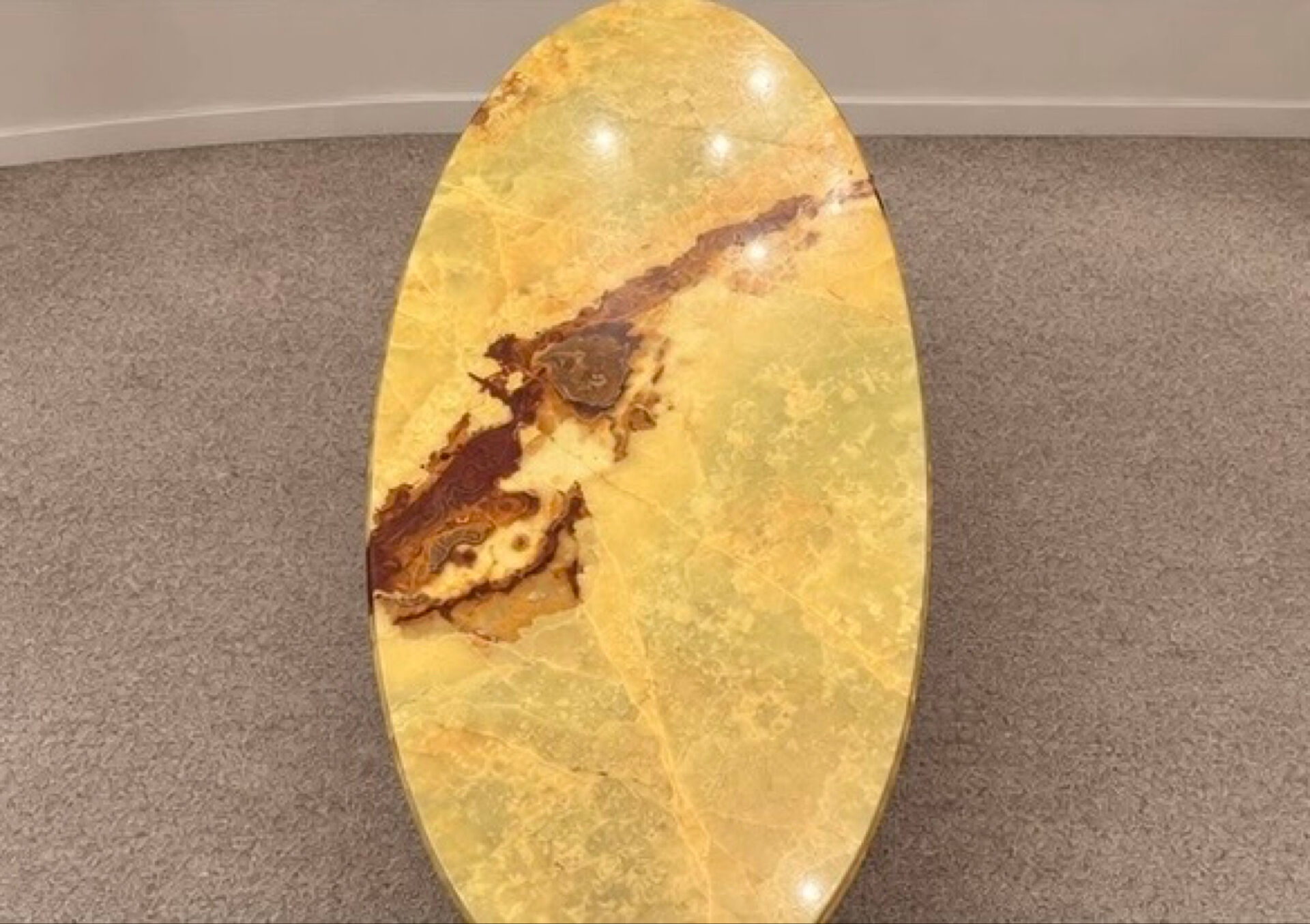 Large oval coffee table in yellow marble and gold metal, classic style.