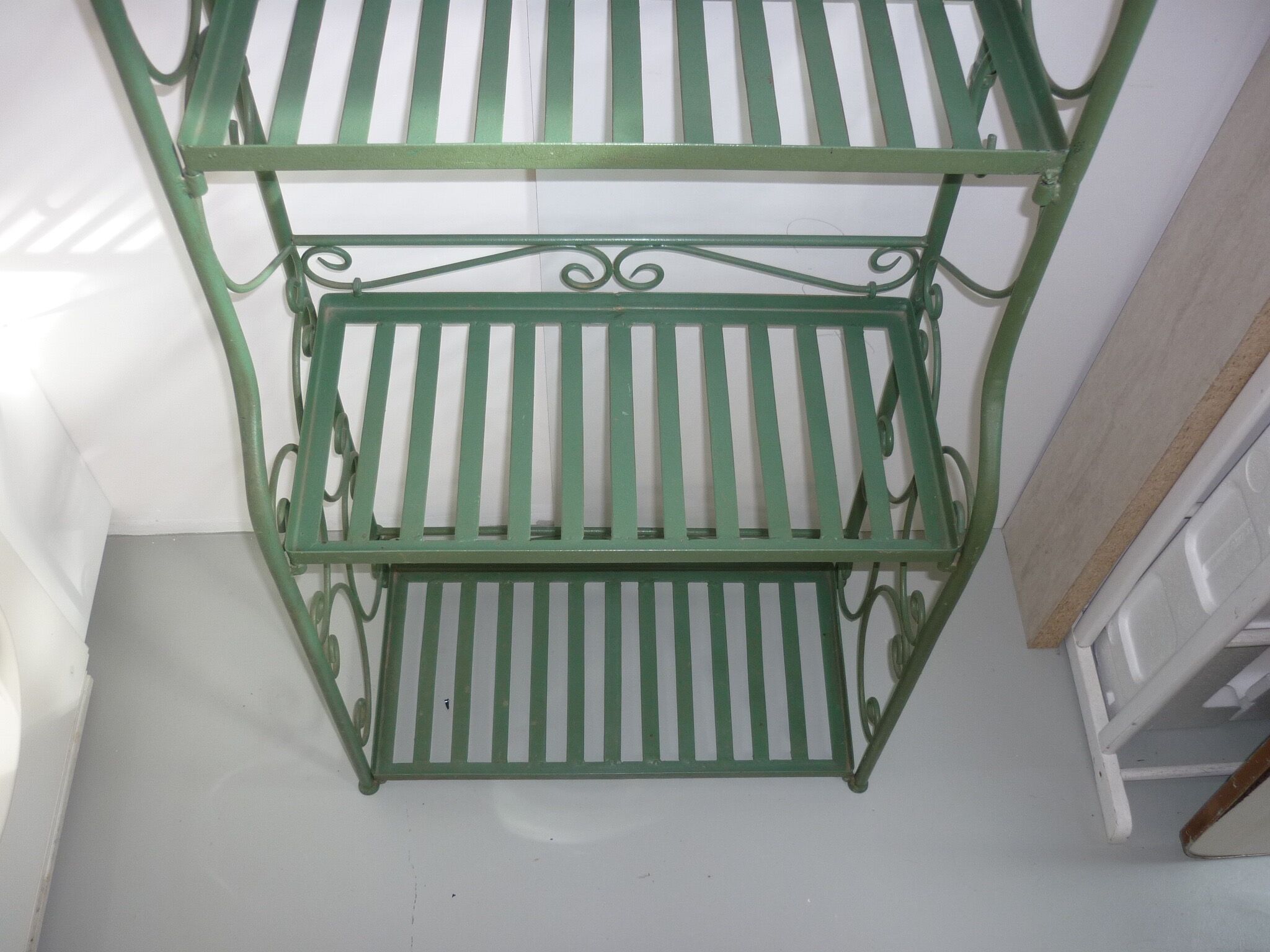 Folding green wrought iron shelf