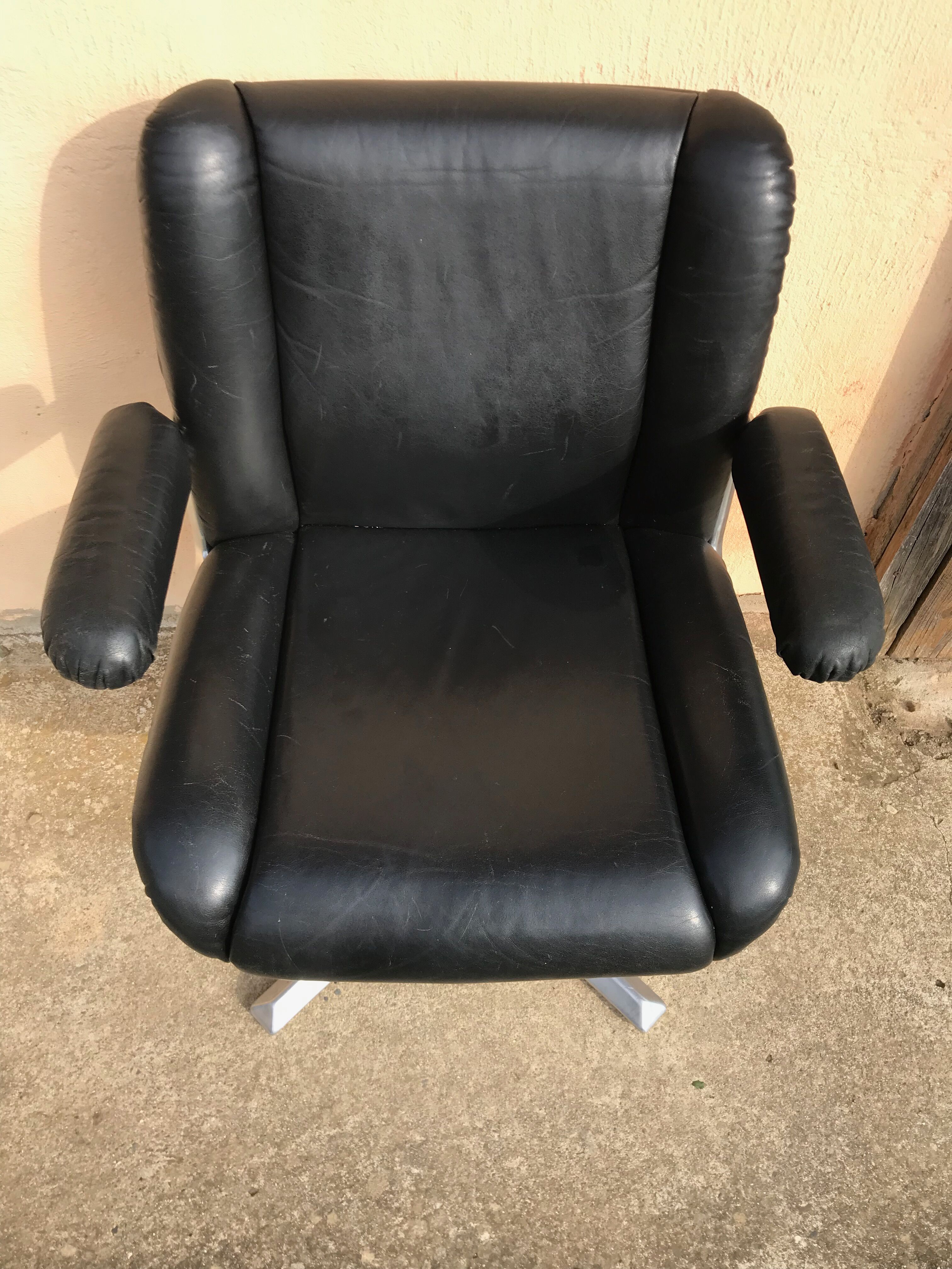 Vintage swivel black leather armchair