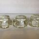 Set of three thick moulded glass candle holders.