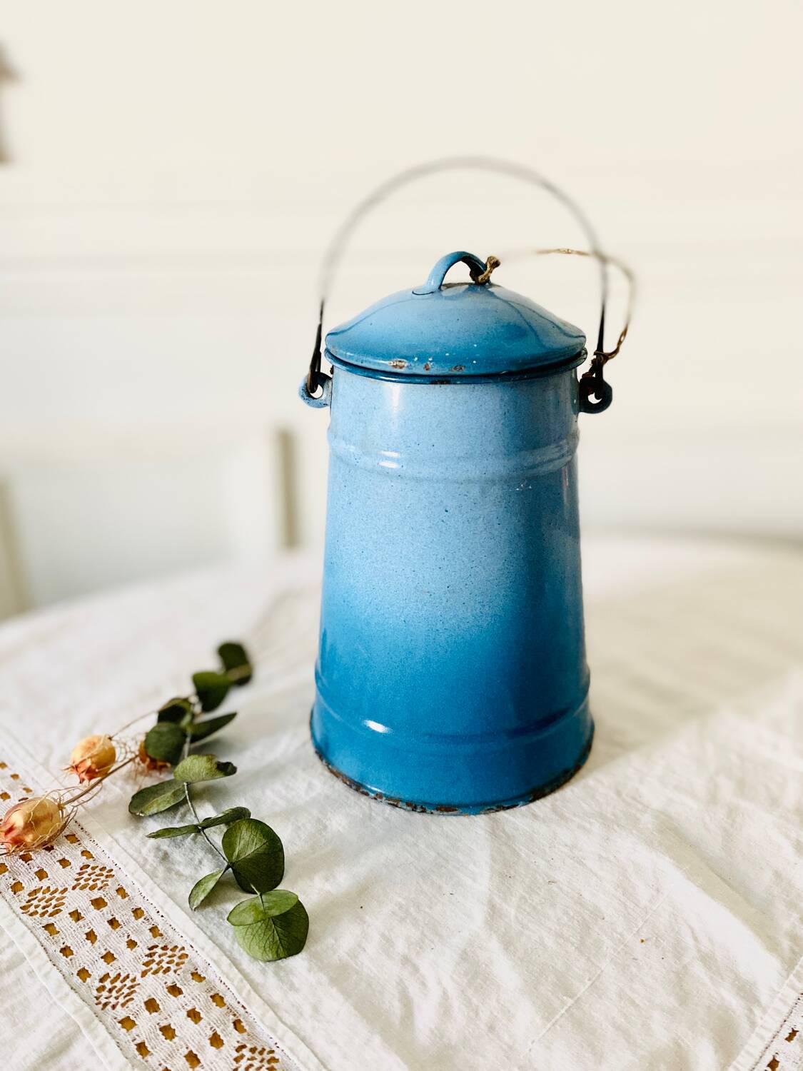 Old vintage milk jug in degraded blue enameled sheet metal