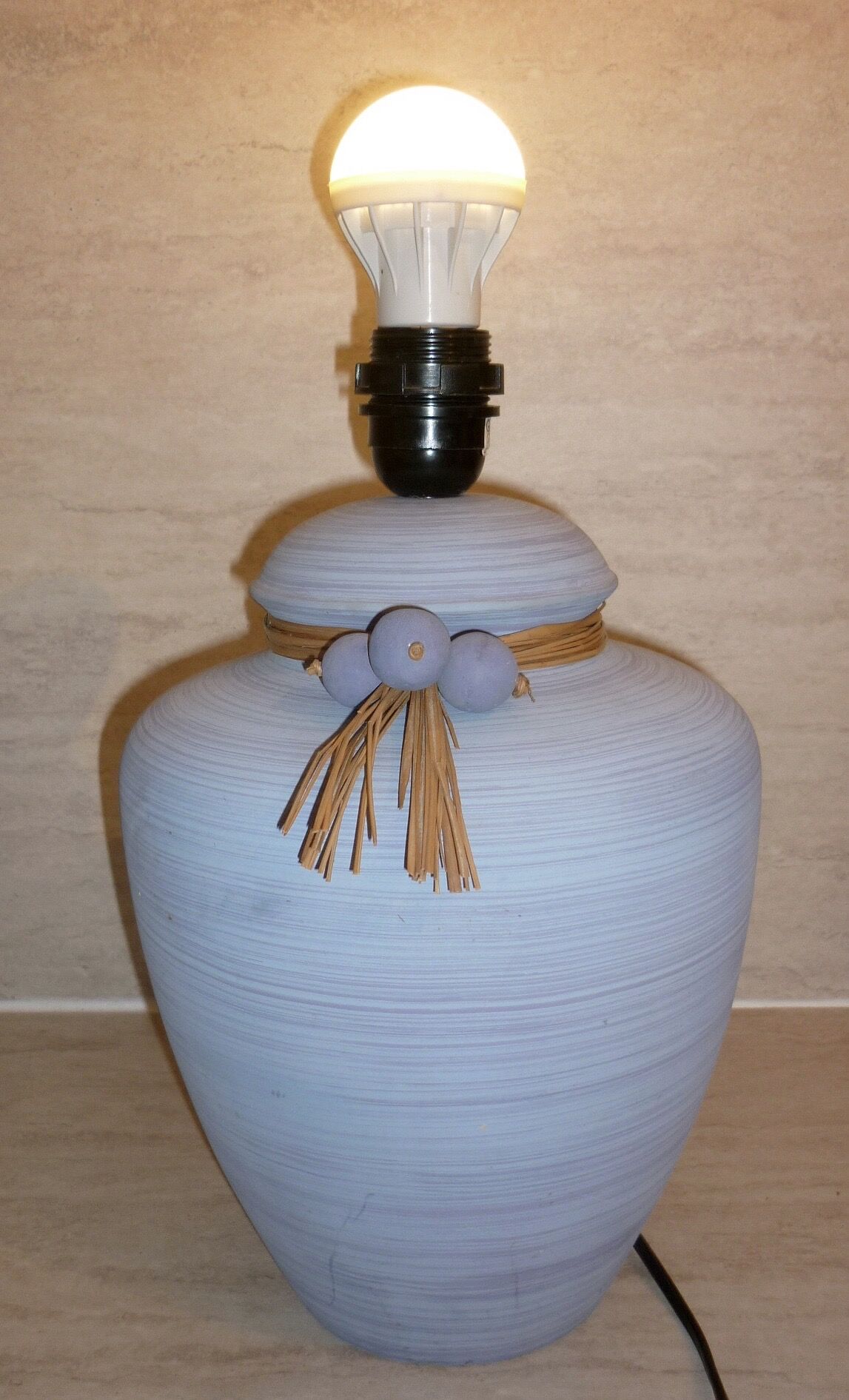 Vintage ceramic lamp foot with ball necklace and raffia.
