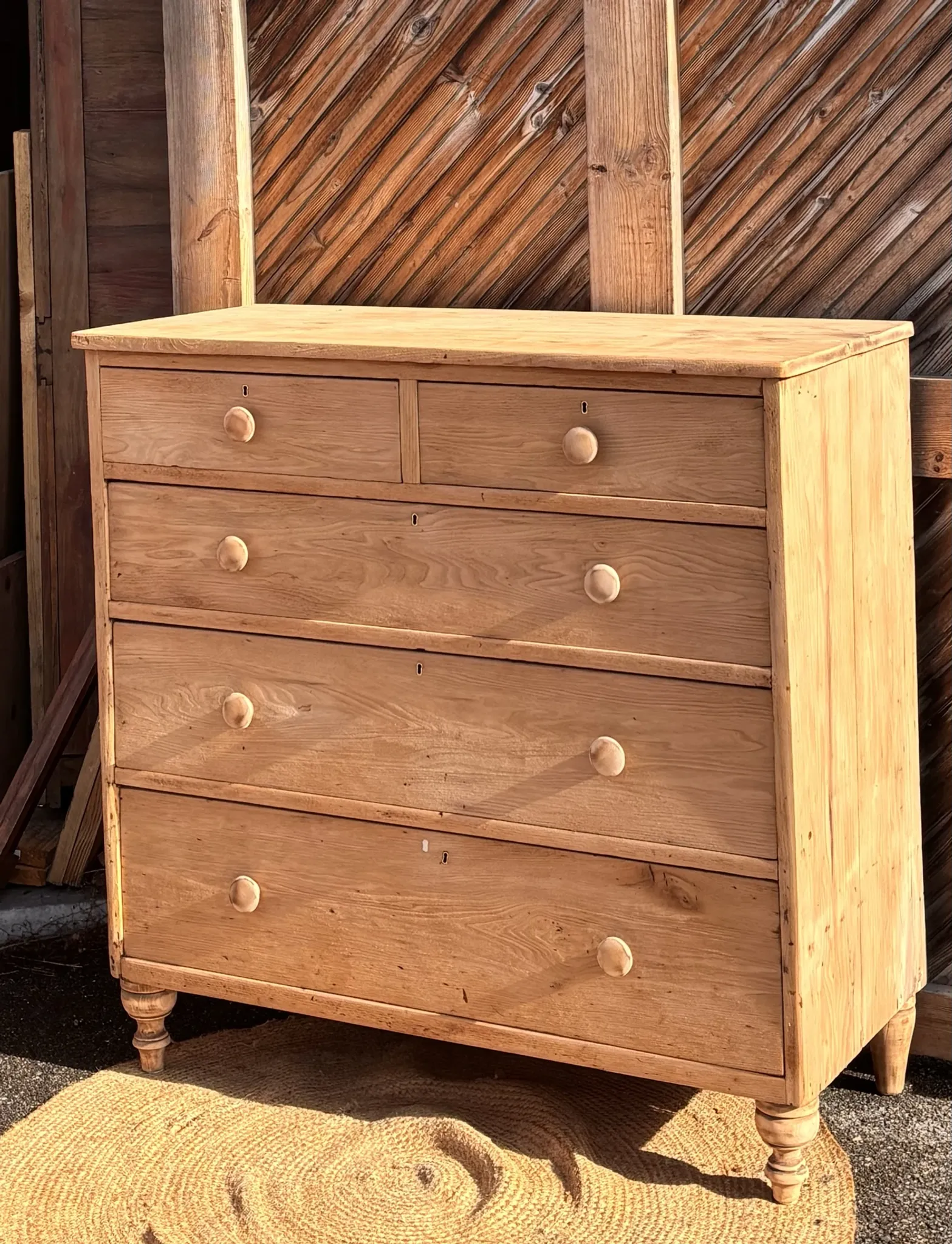 Large antique English chest of drawers in raw solid oak.