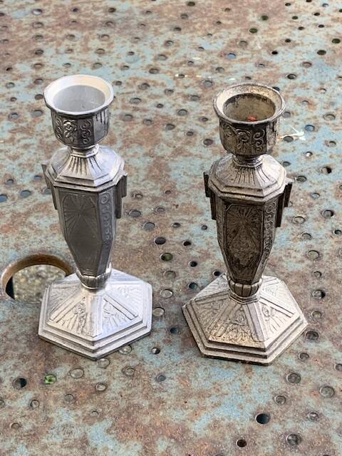 Pair of metal candlesticks, chiseled with a statuette in front, rose pattern in relief, art deco